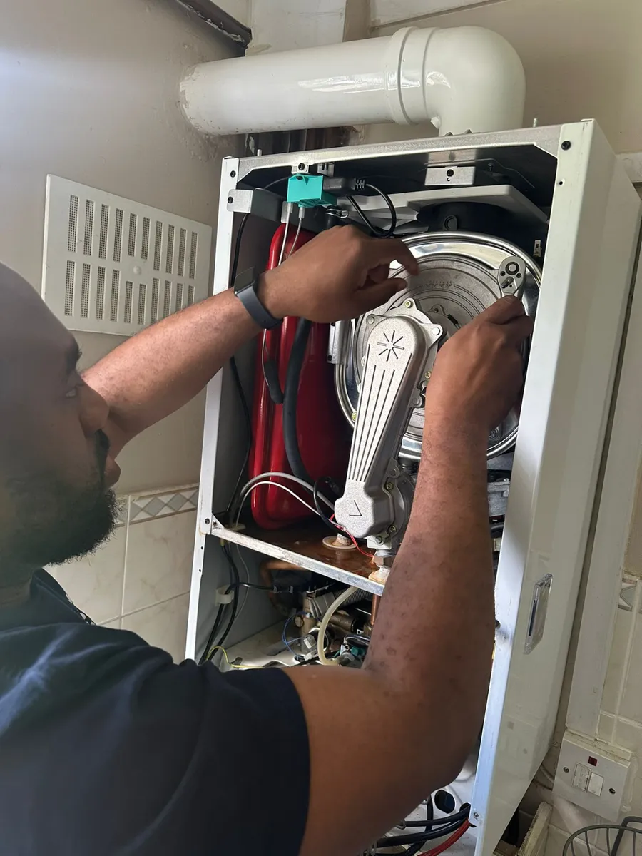Teon, Gas Safe registered engineer, working inside an open boiler in Birmingham